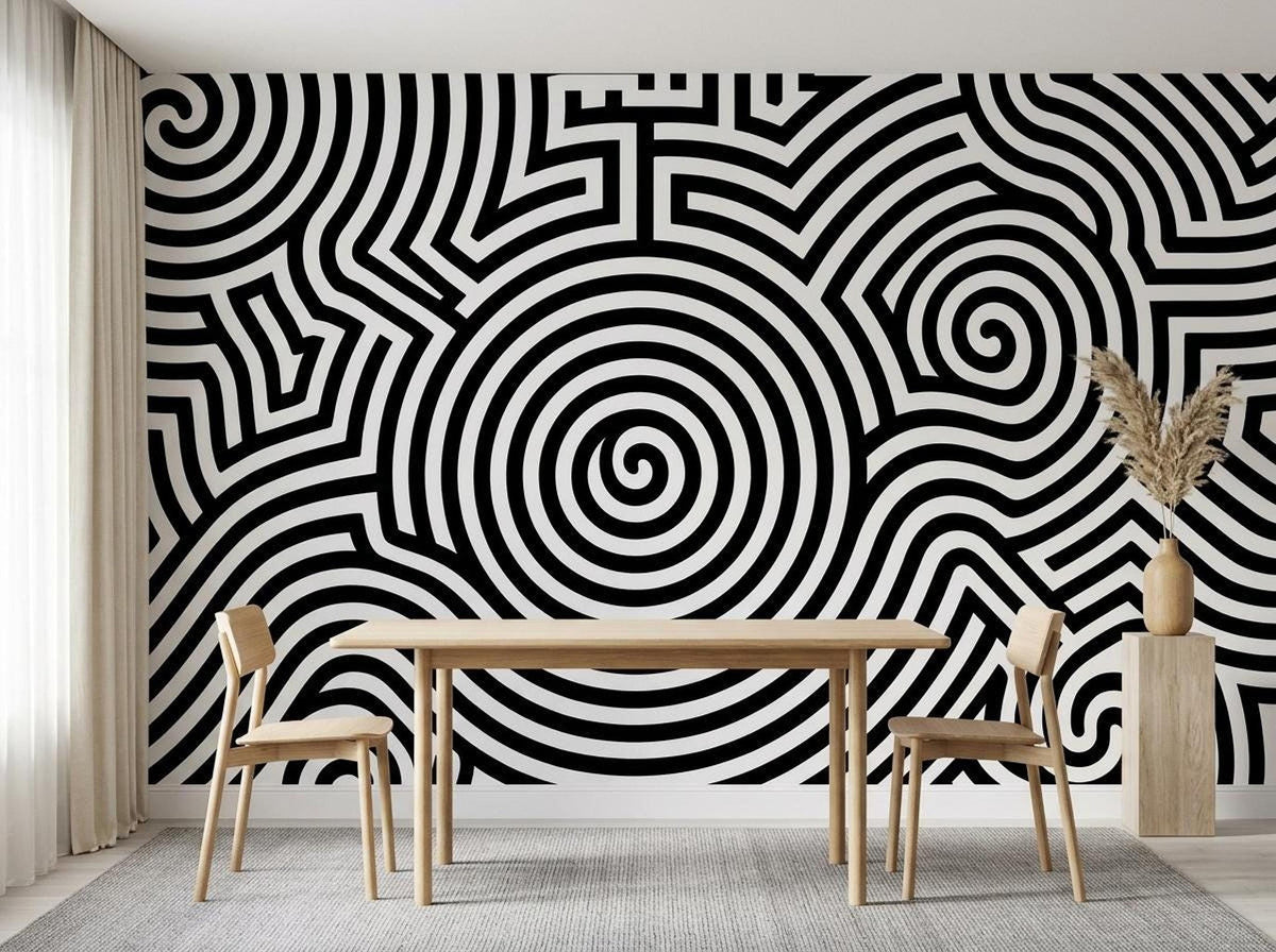 A dining space displays a black and white geometric spiral wallpaper mural on the wall behind a wooden dining table and chairs.