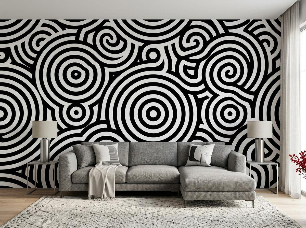 A living room features a black and white geometric patterned accent wall behind a gray sectional sofa and a patterned rug.