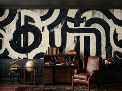 A home office setup with a wooden desk, a brown leather armchair, a globe, and the abstract black and white brushstroke wallpaper in the background.
