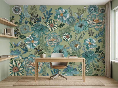 A wooden desk and a grey office chair are positioned in front of a sage green wall mural covered in detailed vintage floral patterns.