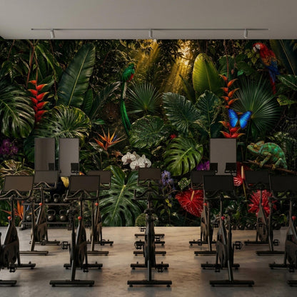 A room with black exercise bikes positioned in front of a dark tropical rainforest mural.